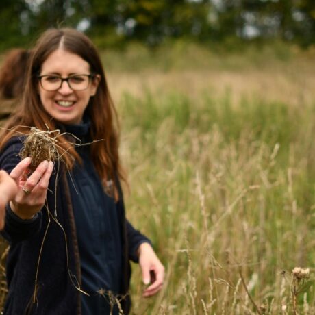 Person holding soil sample in hand in front of a phone taking the same picture