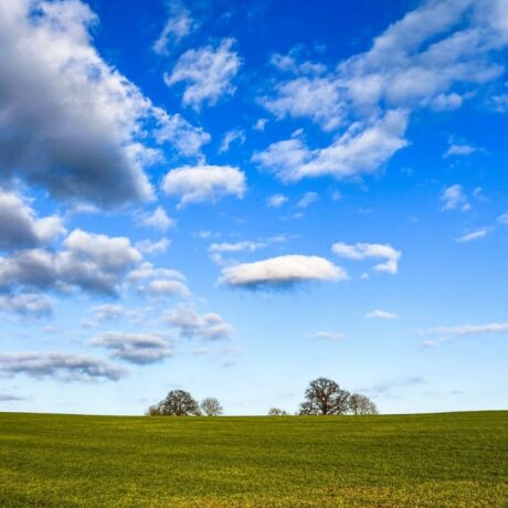 clouds in blue sky over green field
